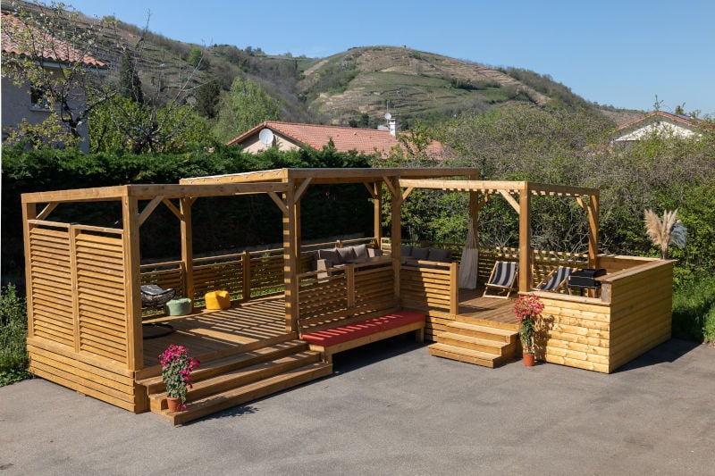 Nature Bois Concept – En exclusivité sur notre boutique, la terrasse sur pilotis avec sa pergola en kit vous offre une structure complète avec un ombrage directement incorporé